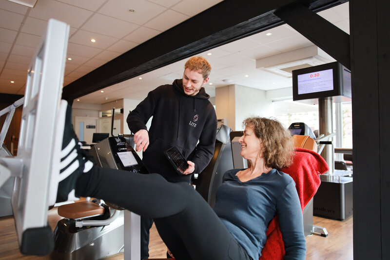 Trainer begeleidt lid op milon